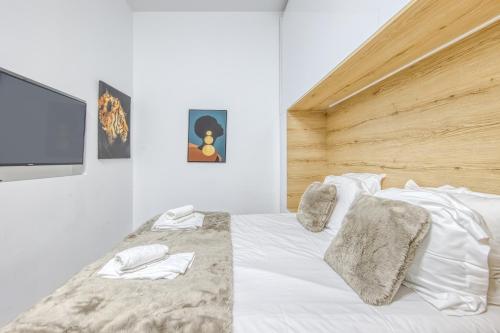 a bedroom with a white bed with a wooden headboard at Studio Cosy Bordeaux Centre in Bordeaux
