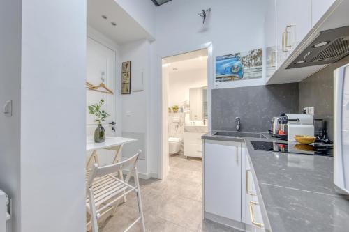 une cuisine avec des armoires blanches et un comptoir dans l'établissement Studio Cosy Bordeaux Centre, à Bordeaux