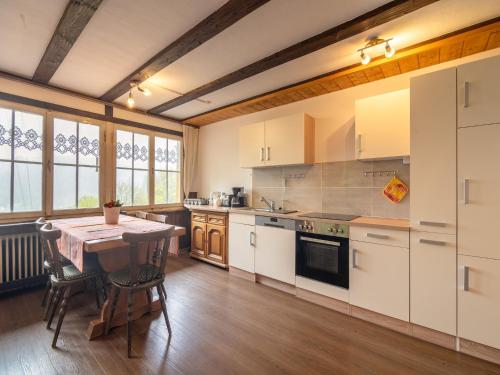 a kitchen with white cabinets and a table and chairs at Wald-Wohnung in Todtmoos in Todtmoos