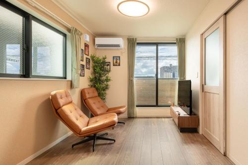 a office with a leather chair and a television at Ici Japon Village in Tokyo