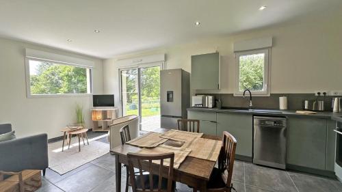 une cuisine avec une table et une salle à manger dans l'établissement La maison neuve, à Veyrac