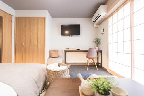 a bedroom with a bed and a desk with a television at b&今里店 in Osaka