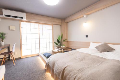 a bedroom with a bed and a desk and a window at b&今里店 in Osaka