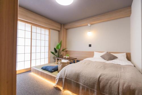 a bedroom with a bed and a large window at b&今里店 in Osaka
