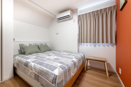 a small bedroom with a bed and a window at Ici Japon Village in Tokyo