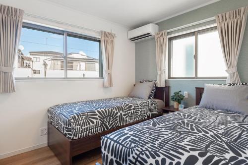 a bedroom with two beds and a window at Ici Japon Village in Tokyo
