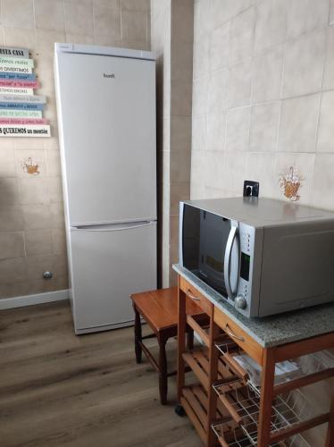 a microwave on a table next to a refrigerator at Casa Rosales in La Orotava