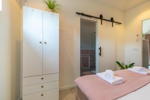 a bedroom with two beds and a large white cabinet at Welcome in - Appartement Bed by Al - Achterstraat 9 Kortgene in Kortgene