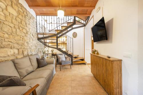 a living room with a couch and a staircase at Cal Comorera in Masoteras