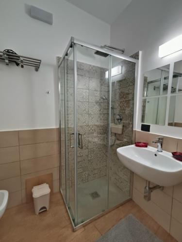 a bathroom with a glass shower and a sink at Momoflat in Agrigento