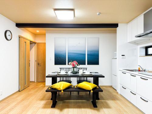 a kitchen with a table with yellow pillows at JS暁宅-三江 mie in Osaka