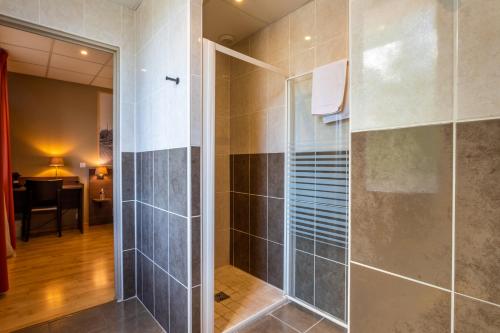 a bathroom with a shower with a glass door at Logis Hôtels et restaurant La Pause Rn7 in La Coucourde