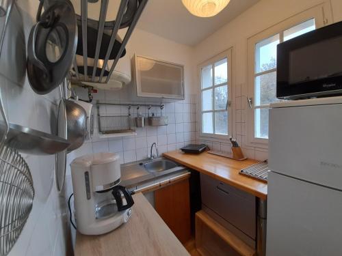 une petite cuisine avec un évier et un réfrigérateur dans l'établissement T2 lumineux centre-ville avec Wi-Fi, lave-linge et lave-vaisselle - FR-1-541-122, à La Roche-Posay