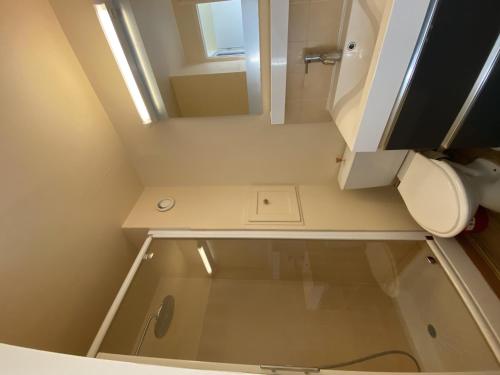 une petite salle de bain avec toilettes et miroir dans l'établissement T2 avec terrasse et Wi-Fi, proche des Thermes du Connétable - FR-1-541-123, à La Roche-Posay