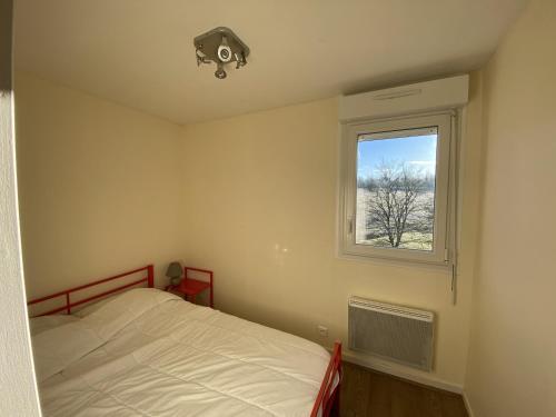 une chambre avec un lit et une fenêtre dans l'établissement T2 avec terrasse et Wi-Fi, proche des Thermes du Connétable - FR-1-541-123, à La Roche-Posay