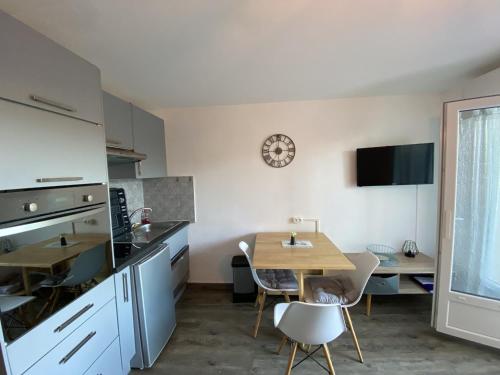 une cuisine et une salle à manger avec une table et une salle à manger dans l'établissement Charmant T2 avec terrasse proche des Thermes du Connétable, Wi-Fi, lave-vaisselle - FR-1-541-138, à La Roche-Posay