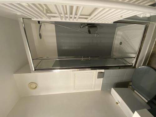 Elle comprend une petite salle de bains pourvue d'une fenêtre en verre. dans l'établissement Charmant T2 avec terrasse proche des Thermes du Connétable, Wi-Fi, lave-vaisselle - FR-1-541-138, à La Roche-Posay