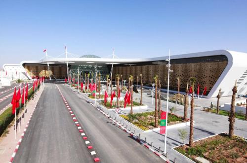 a road with flags in front of a building at Julie Airport Marrakech Apartments in Marrakech