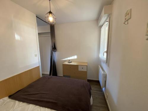 une chambre avec un lit, une commode et une fenêtre dans l'établissement Charmant T2 avec terrasse proche des Thermes du Connétable, Wi-Fi, lave-vaisselle - FR-1-541-138, à La Roche-Posay