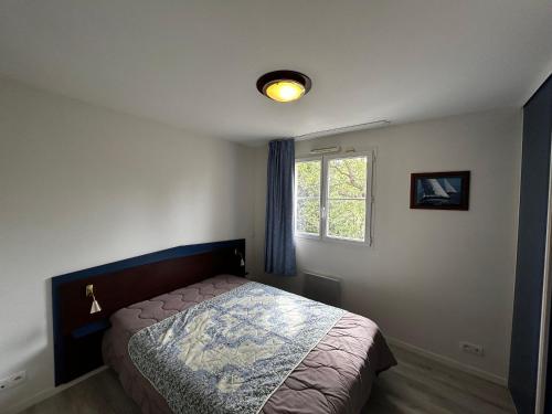 une chambre avec un lit et une fenêtre dans l'établissement T2 avec piscine à 200m des Thermes - FR-1-541-139, à La Roche-Posay