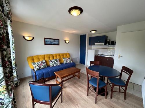 un salon avec un canapé bleu et une table dans l'établissement T2 avec piscine et WiFi à 200m des Thermes - FR-1-541-150, à La Roche-Posay