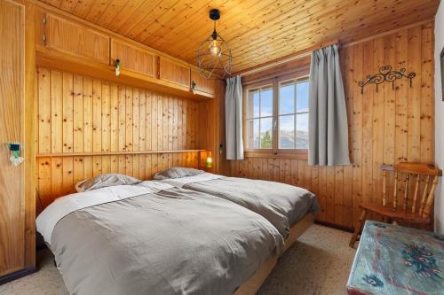 a bedroom with a large bed in a wooden room at Eole - 6 pers - pres des pistes in Nendaz
