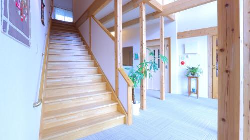 a wooden staircase in a home with wooden beams at Minamiaso Nobara Inn in Minami Aso