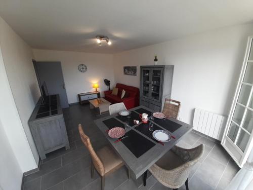 un salon avec une table et un canapé rouge dans l'établissement T2 lumineux avec Wi-Fi au centre de La Roche-Posay - FR-1-541-124, à La Roche-Posay