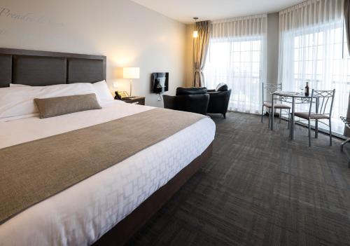 a hotel room with a large bed and a desk at Hôtel et Pavillons Le Petit Manoir du Casino in La Malbaie