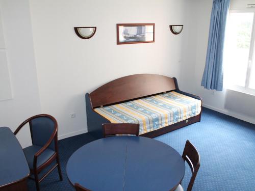 une chambre avec un lit, une table et des chaises dans l'établissement Appartement T3 PMR proche Thermes, piscine & parking - La Roche-Posay - FR-1-541-144, à La Roche-Posay