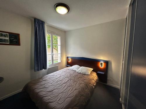 une chambre avec un lit et une fenêtre dans l'établissement Appartement Résidence, Piscine, 200m des Thermes - FR-1-541-149, à La Roche-Posay