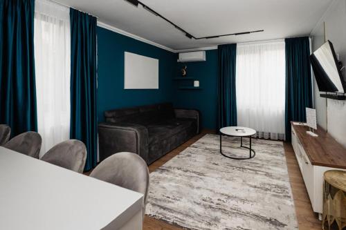 a living room with a black couch and blue walls at Best House in Botoşani
