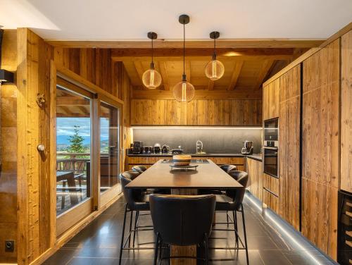 - une cuisine avec des murs en bois, une table et des chaises dans l'établissement Chalet d'Isabella-Lodge Pyrénées, à Bolquère-Pyrénées 2000