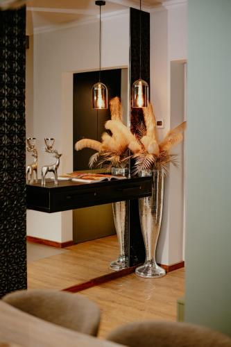 a room with a table with a vase with feathers at Best House in Botoşani