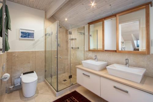 a bathroom with two sinks and a shower at Hermanus Luxury Penthouse in Hermanus