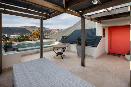 a balcony with a table and a view of the mountains at Hermanus Luxury Penthouse in Hermanus