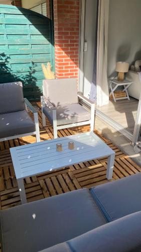 une terrasse avec un banc, une chaise et une table dans l'établissement Studio Le Corail avec terrasse, à Le Touquet-Paris-Plage