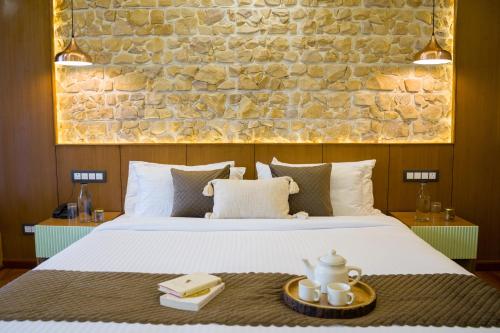 a bedroom with a bed with a stone wall at Alaya Stays 3BHK with Garden -Evaara Woods Ridge in Shimla