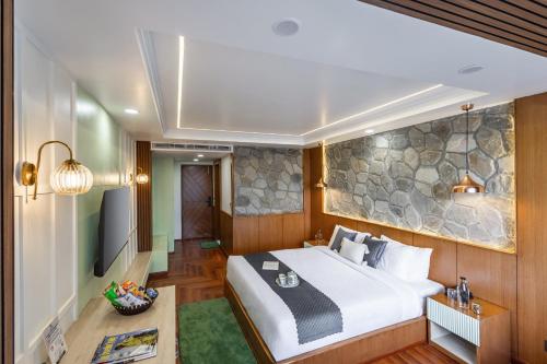 a hotel room with a bed and a tv at Alaya Stays 3BHK with Garden -Evaara Woods Ridge in Shimla