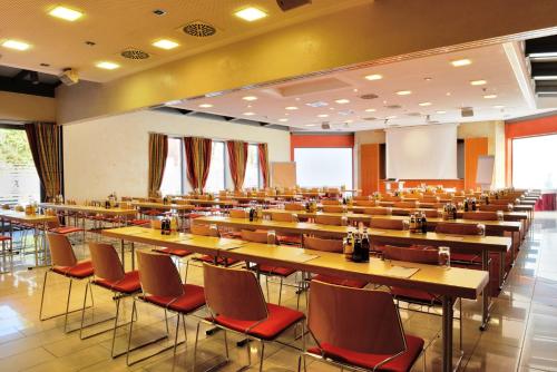 an empty lecture hall with tables and chairs at Ringhotel Alpenhof - Patchworkhotel in Augsburg