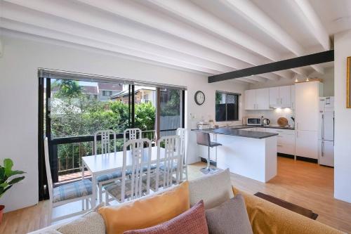 a kitchen and living room with a table and chairs at Clarence Corner - Contemporary meets Cottage Style in Brisbane
