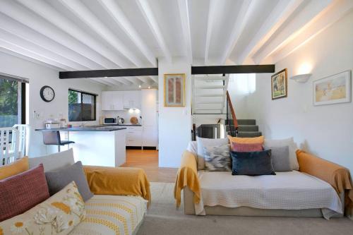a living room with a couch and a kitchen at Clarence Corner - Contemporary meets Cottage Style in Brisbane