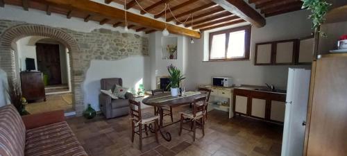 una cucina con un tavolo e sedie in una stanza di Il Poggiolo ad Anghiari