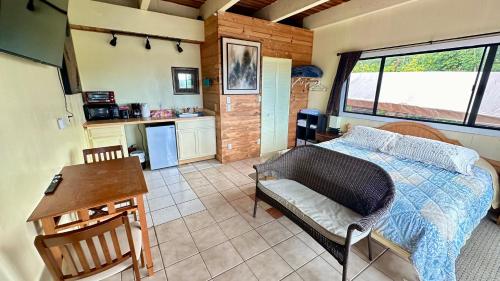 a bedroom with a bed and a table and a kitchen at Coffee Garden in Captain Cook