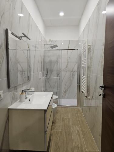 a bathroom with a sink and a shower and a toilet at Be Your Home - La Darsena Guest House in Civitavecchia