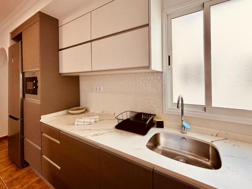 una cocina con fregadero y ventana en Click&Guest - Atlantic Sun House in Playa Arinaga, en Agüimes