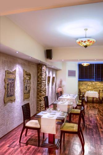 ein Restaurant mit Tischen und Stühlen in einem Raum in der Unterkunft Nicola Hotel in Athen