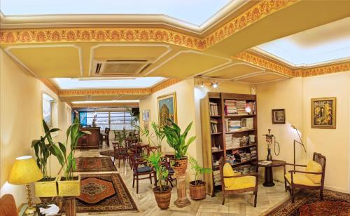 een woonkamer gevuld met veel meubels en planten bij Nicola Hotel in Athene