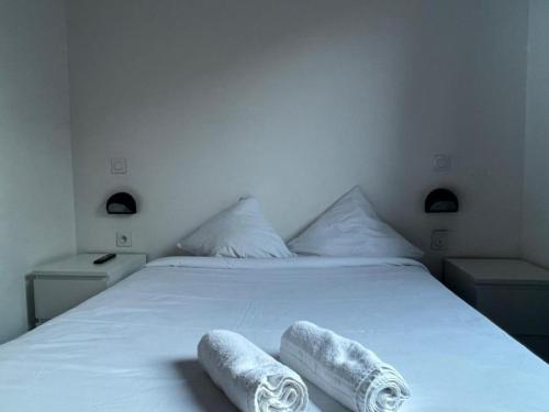 a bedroom with a white bed with towels on it at Résidence Internationale De Paris in Paris