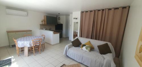 un salon avec un canapé et une table dans l'établissement Mini villa - T2 climatisé, proche des plages, à Eccica-Suarella